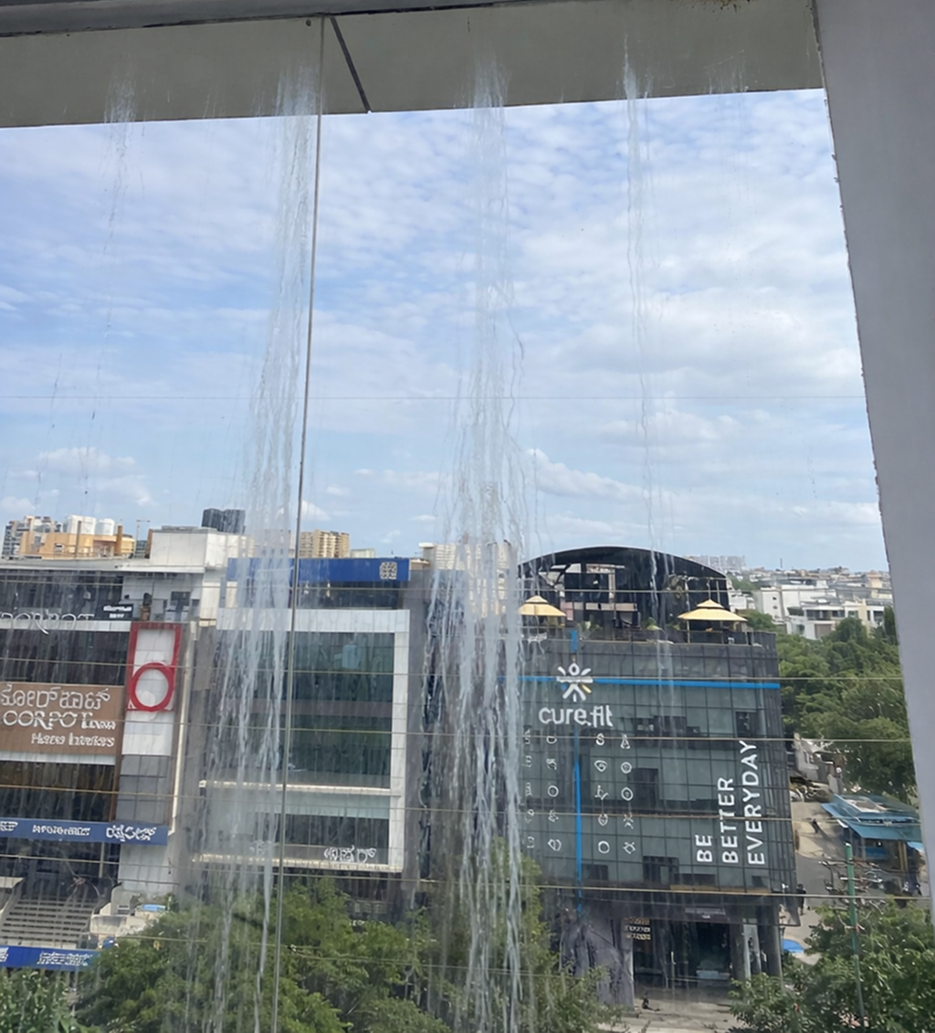 Before — mineral stained commercial glass facade Bangalore
